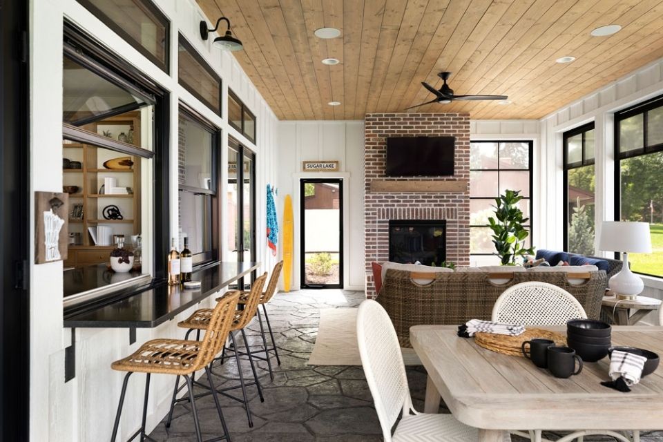 Lake front three season porch with stools and fireplace 